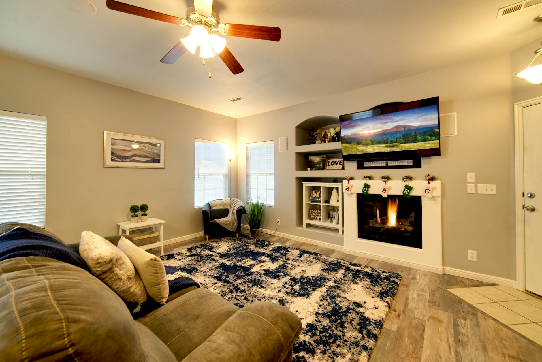 Nowoczesny salon z białą obudową kominka i wygodną kanapą