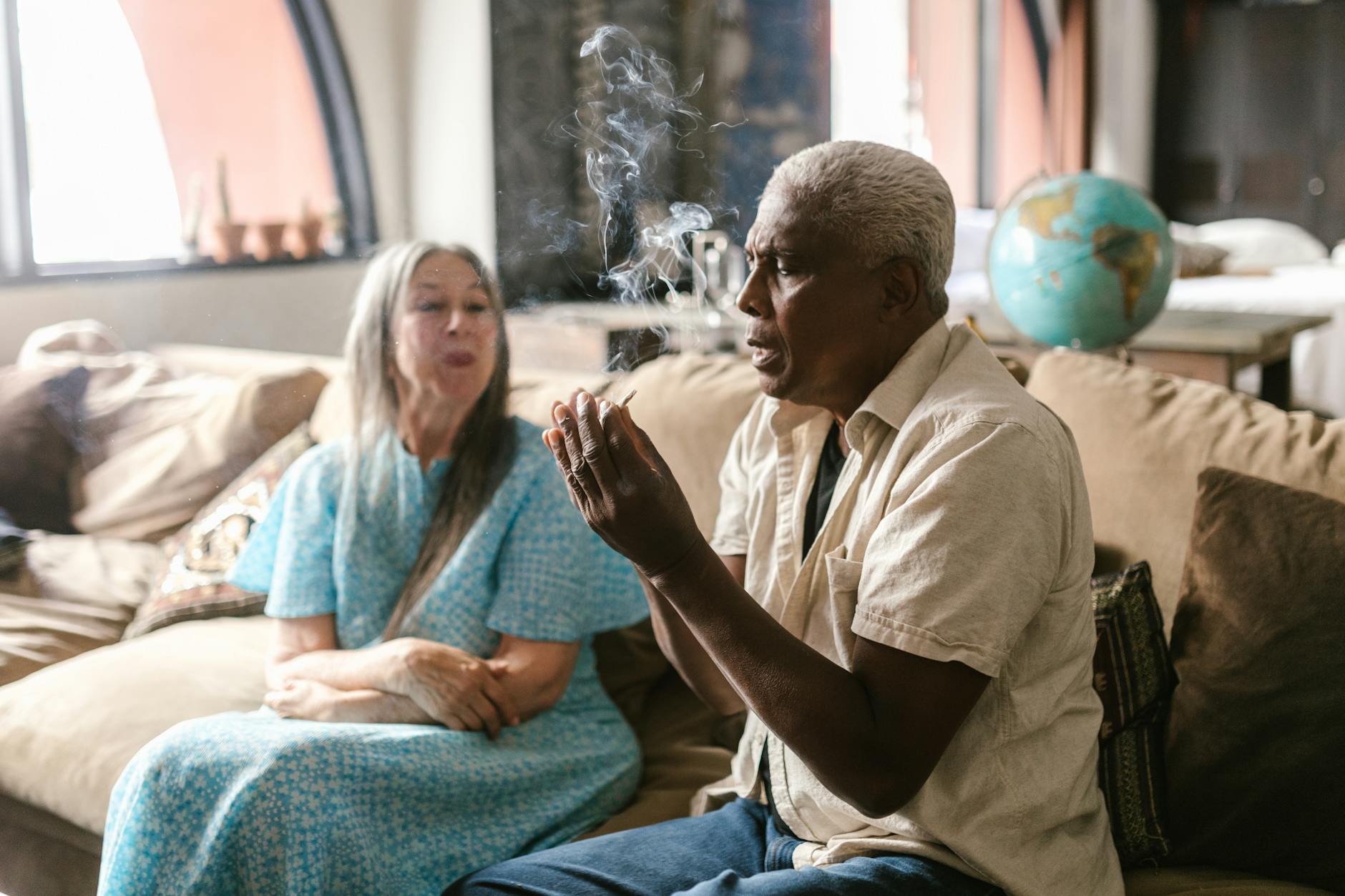 Starsze małżeństwo pali jointa w przytulnym salonie