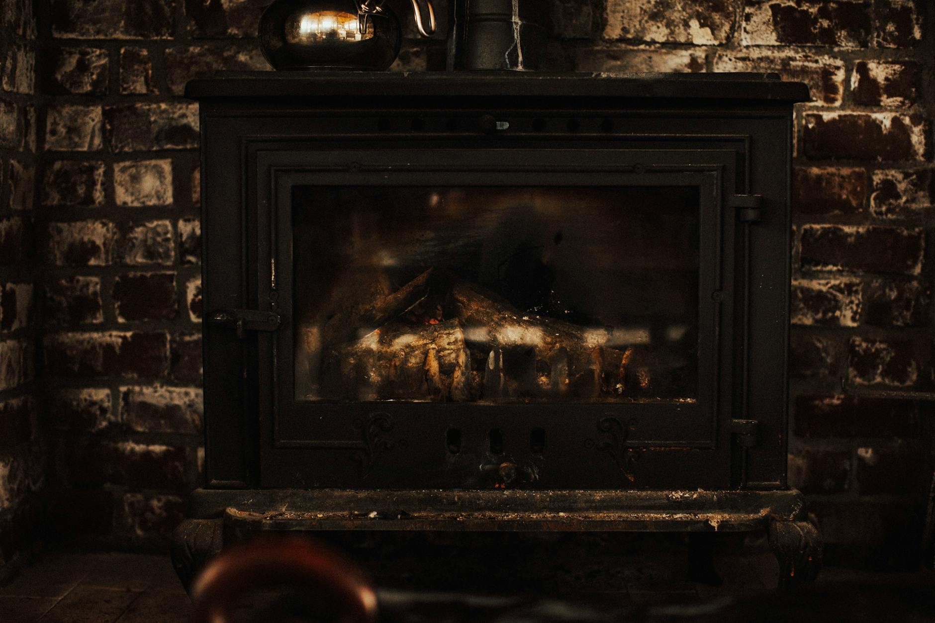 Klasyczny kominek w ceglanej ścianie w przytulnym, zimowym wnętrzu